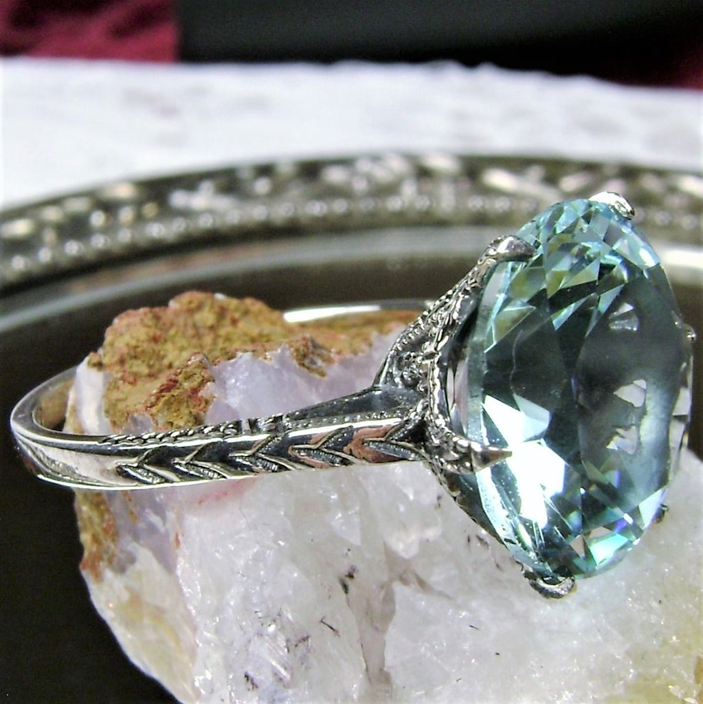 a fancy ring with a blue topaz sits on top of a rock