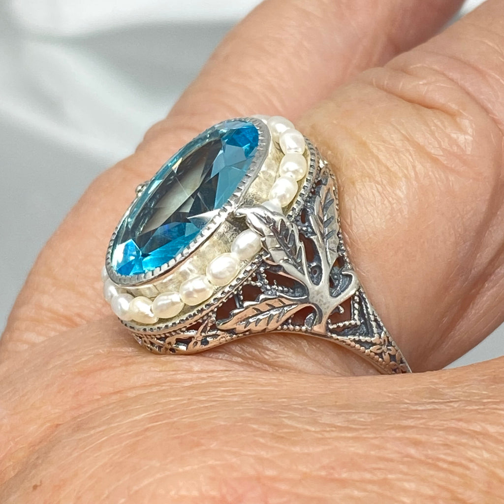 Blue Aquamarine Ring, Sterling Silver Leaf Filigree, Pearl Frame, Vintage Jewelry, Silver Embrace Jewelry, D8 Leaf Pearl Design, Ring with blue gemstone and pearl accents on a hand