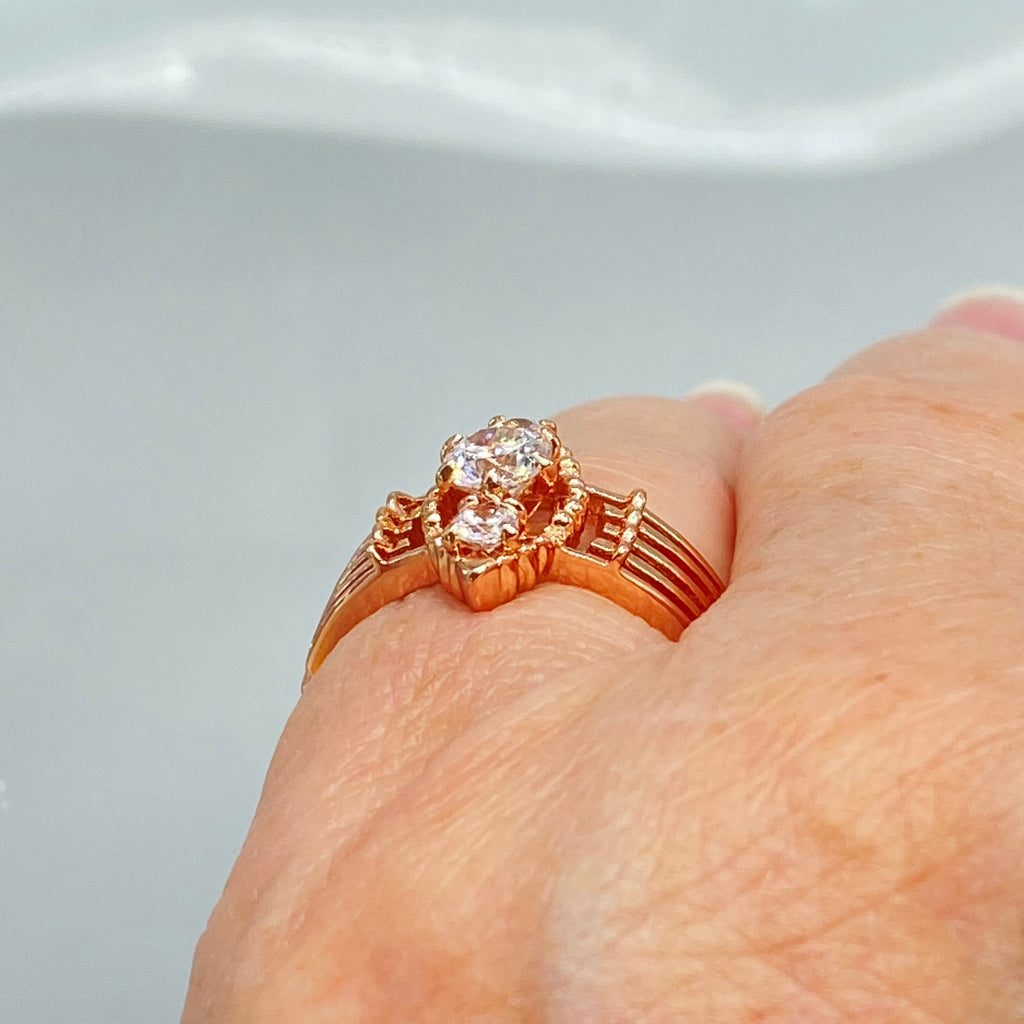 Rose gold ring with multiple sparkling gems on a hand, a three stone ring with a White CZ center. Rose Gold plated Sterling Silver Art Deco Filigree, fine detail, Silver Embrace Jewelry, Xanadu D164