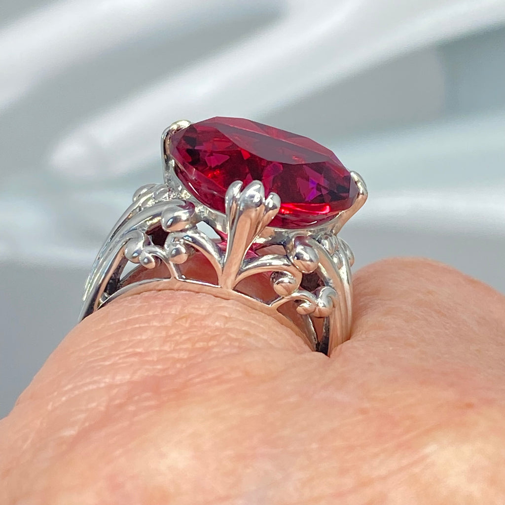 Silver ring with a red gemstone on a finger against a neutral background, Ruby Ring, Heart Ring, Sterling Silver Filigree, silver Embrace Jewelry, D213