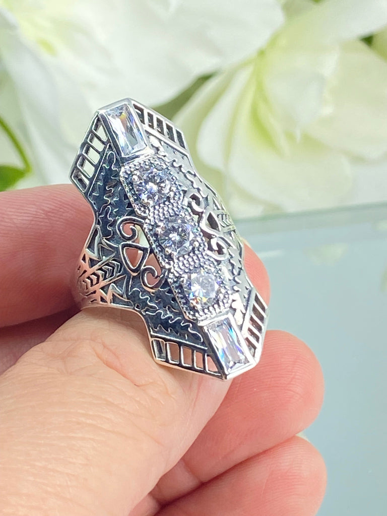 White CZ Art Deco Ring, with three round stones and two baguette stones, intricate 1930s filigree adorns the ring and the band. Silver Embrace Jewelry, D214, Long Deco