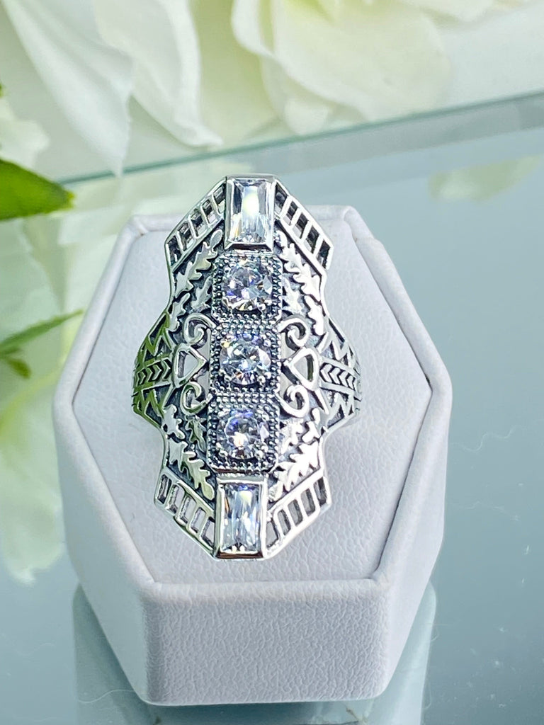 White CZ Art Deco Ring, with three round stones and two baguette stones, intricate 1930s filigree adorns the ring and the band. Silver Embrace Jewelry, D214, Long Deco