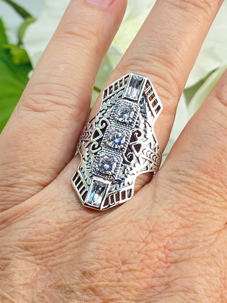 White CZ Art Deco Ring, with three round stones and two baguette stones, intricate 1930s filigree adorns the ring and the band. Silver Embrace Jewelry, D214, Long Deco