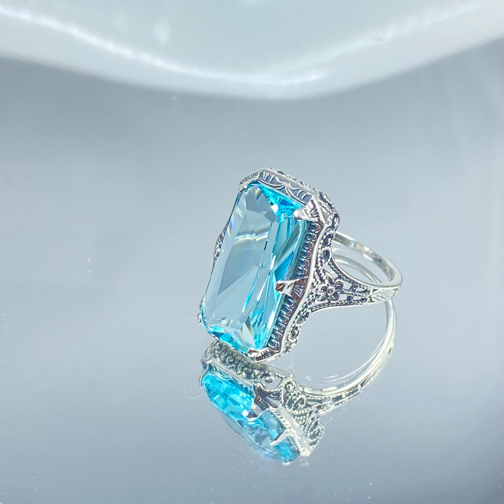 Simulated Aquamarine Ring, Edwardian Jewelry, Sterling silver filigree, Silver Embrace Jewelry D232, Aquamarine & Silver ring with a large blue gemstone on a mirror