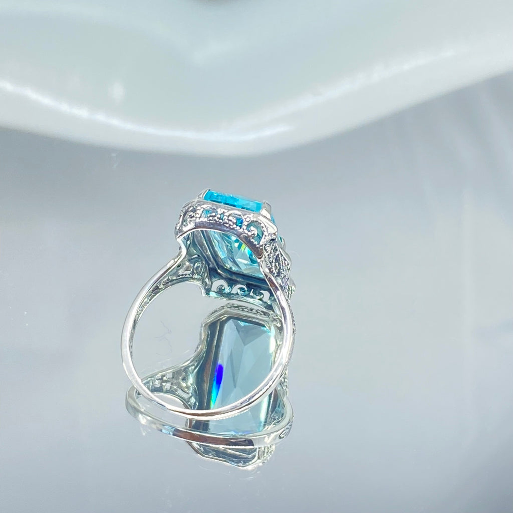 Simulated Aquamarine Ring, Edwardian Jewelry, Sterling silver filigree, Silver Embrace Jewelry D232, Aquamarine & Silver ring with a large blue gemstone on a mirror