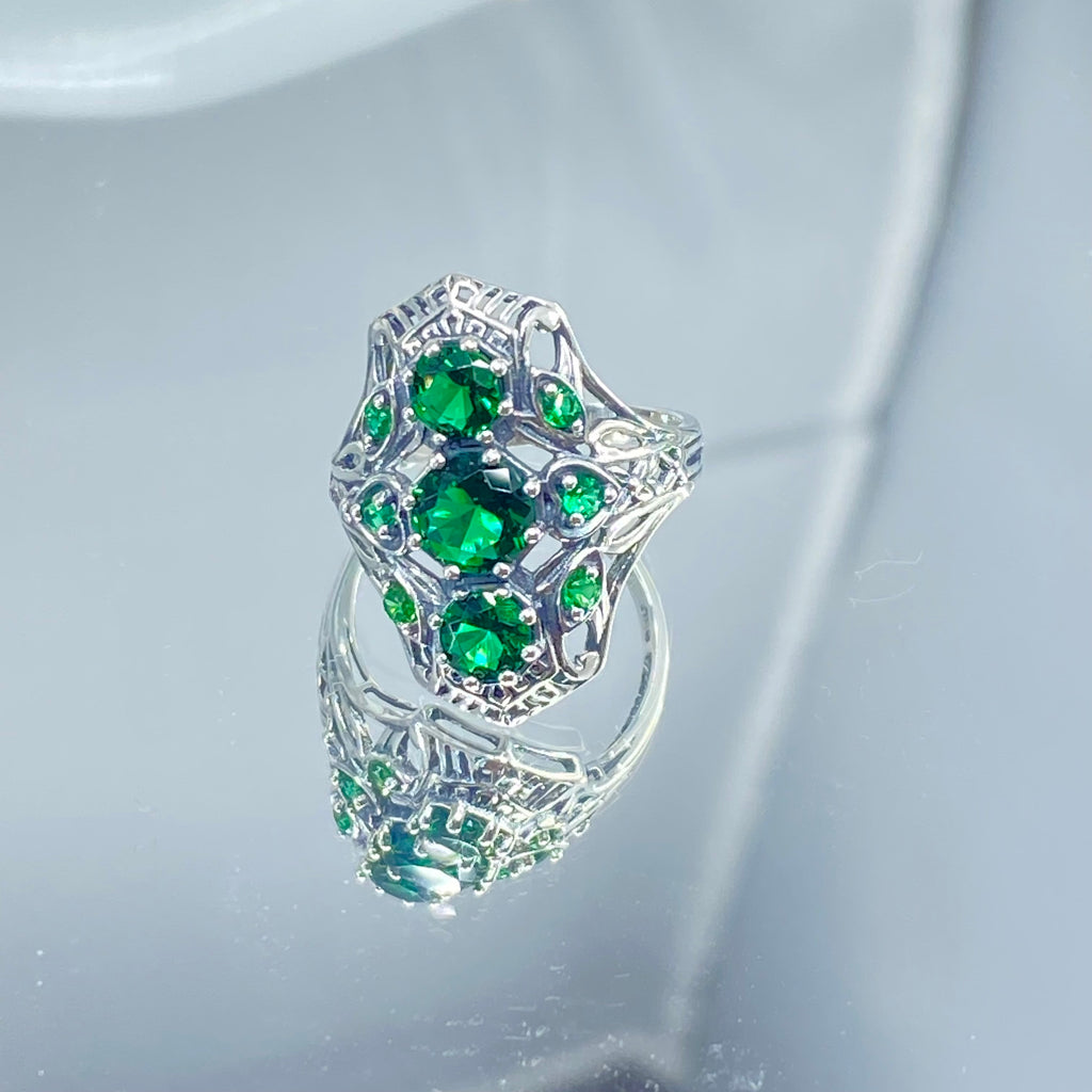 Emerald Ring with 9 Gems, sterling silver filigree, D69, 9-Gem Ring, Silver Embrace jewelry, Silver ring with green gemstones on a reflective surface