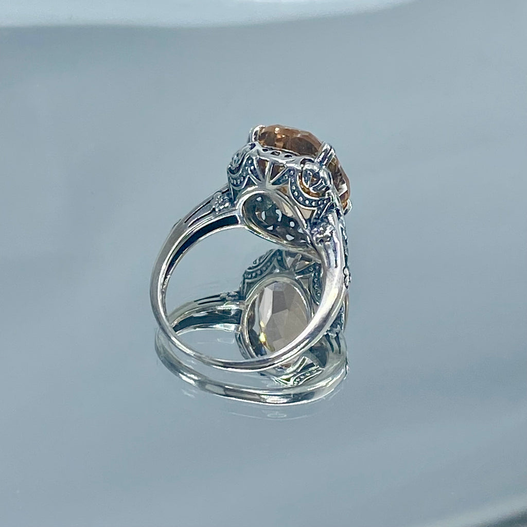 Peach Topaz ring, Sterling Silver floral Filigree, Edward design #D70, Silver Embrace Jewelry Silver ring with a large Peach gemstone on a reflective background