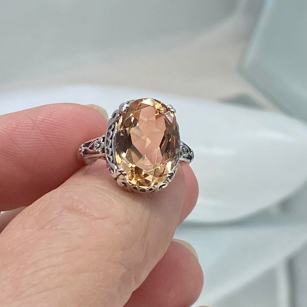 Peach Topaz ring, Sterling Silver floral Filigree, Edward design #D70, Silver Embrace Jewelry Silver ring with a large peach-colored gemstone held by a hand