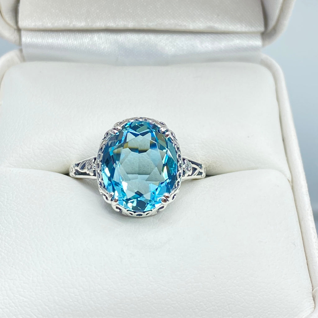 Silver ring with a blue topaz gemstone in an open jewelry box, Aquamarine Ring, Sky Blue simulated oval gemstone, Sterling Silver floral filigree, Edward design #D70z