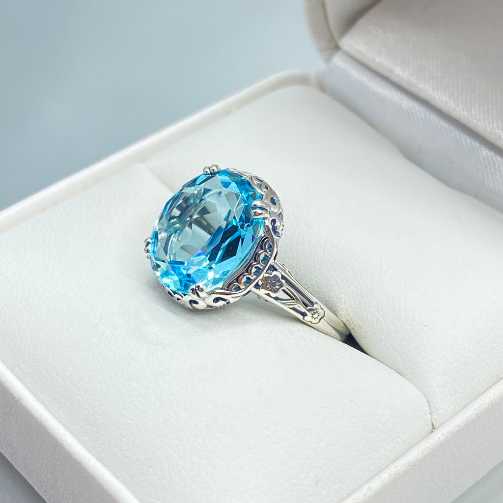 Silver ring with a blue topaz gemstone in an open jewelry box, Aquamarine Ring, Sky Blue simulated oval gemstone, Sterling Silver floral filigree, Edward design #D70z