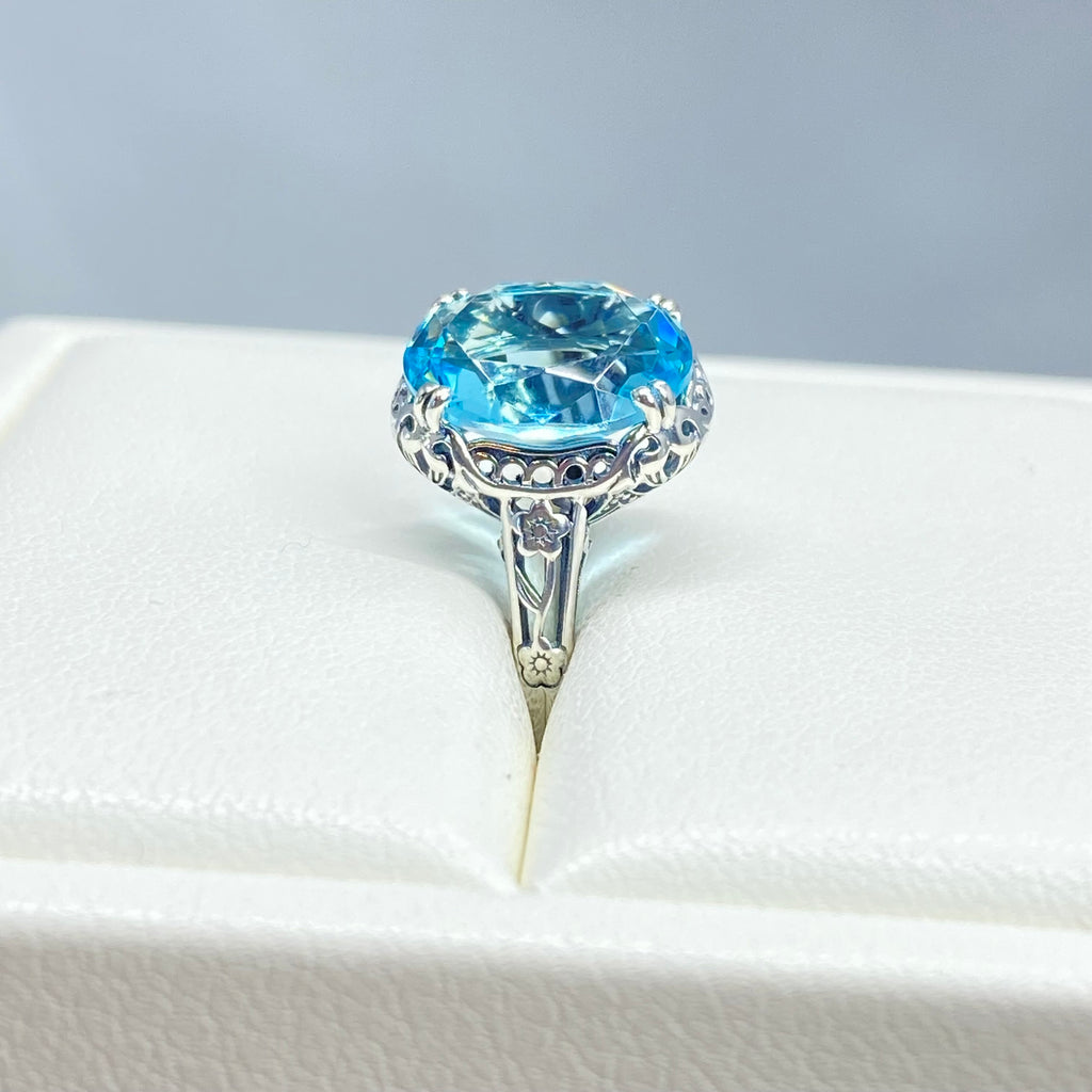 Silver ring with a blue topaz gemstone in an open jewelry box, Aquamarine Ring, Sky Blue simulated oval gemstone, Sterling Silver floral filigree, Edward design #D70z