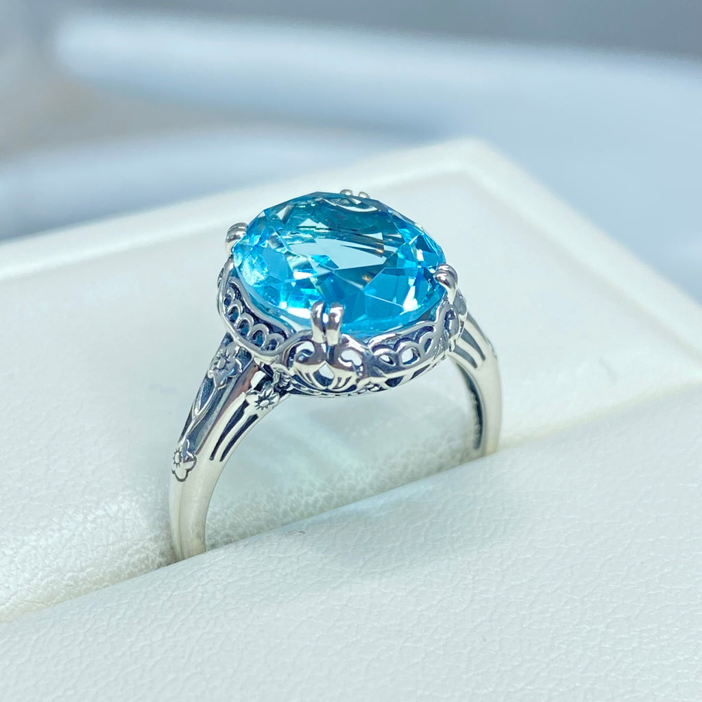 Silver ring with a blue topaz gemstone in an open jewelry box, Aquamarine Ring, Sky Blue simulated oval gemstone, Sterling Silver floral filigree, Edward design #D70z