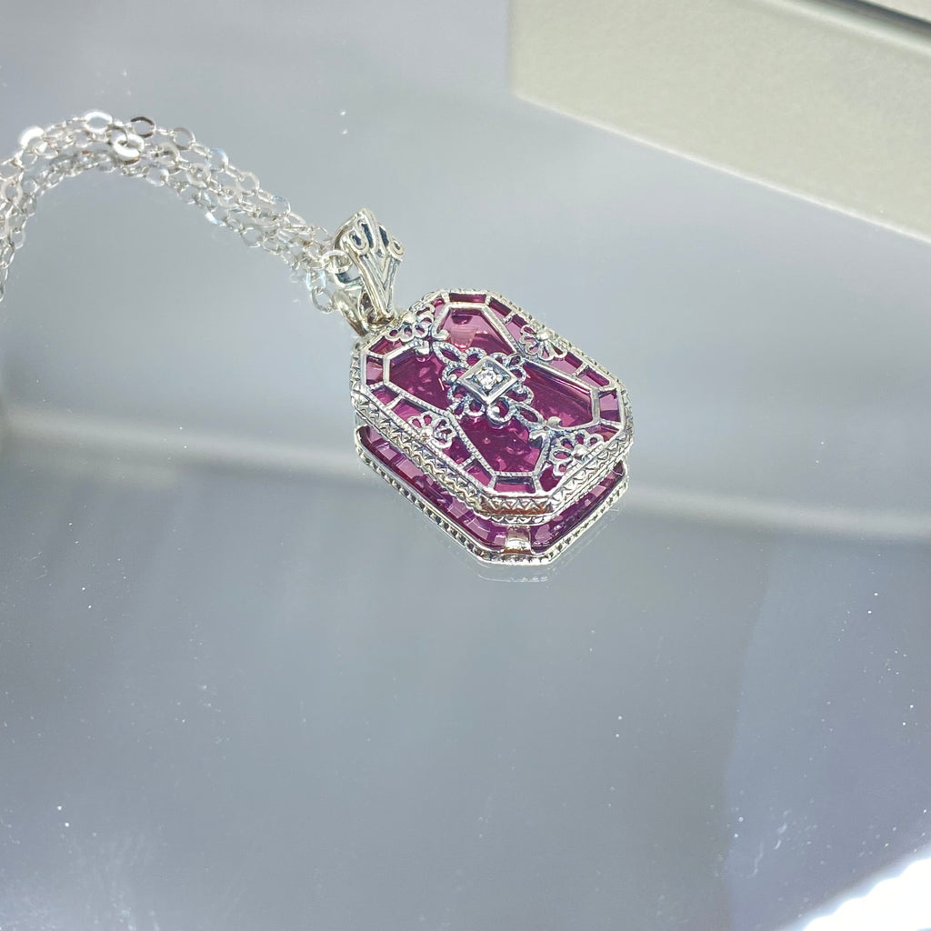 Pink Camphor Glass pendant with a CZ gem inset in the center, sterling silver filigree edging and across the glass face in window pane style, Silver Embrace Jewelry, P203
