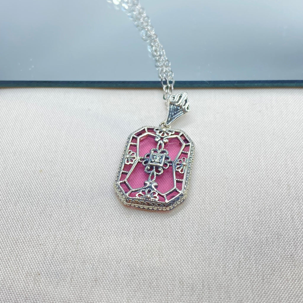 Pink Camphor Glass pendant with a CZ gem inset in the center, sterling silver filigree edging and across the glass face in window pane style, Silver Embrace Jewelry, P203
