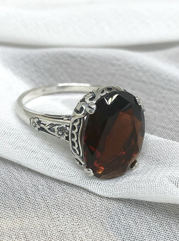 Simulated Red Garnet Ring, Sterling Silver floral filigree, Edward Design #D70, side and front view on a flat surface