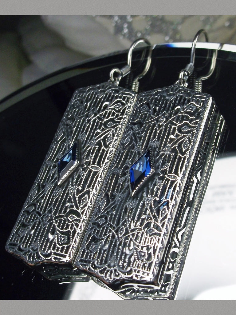Rectangle Art Deco style earrings with fine lace filigree and a diamond shaped blue sapphire gemstone in the center of the lace filigree field, traditional shepherd hook style ear wire closures