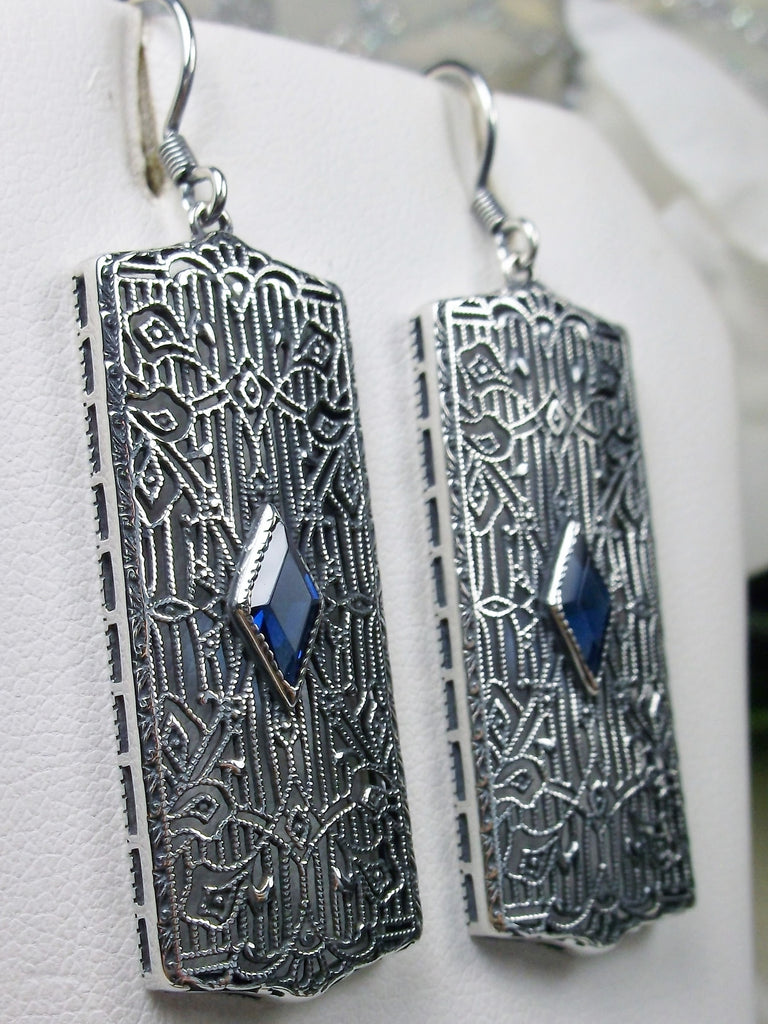 Rectangle Art Deco style earrings with fine lace filigree and a diamond shaped blue sapphire gemstone in the center of the lace filigree field, traditional shepherd hook style ear wire closures