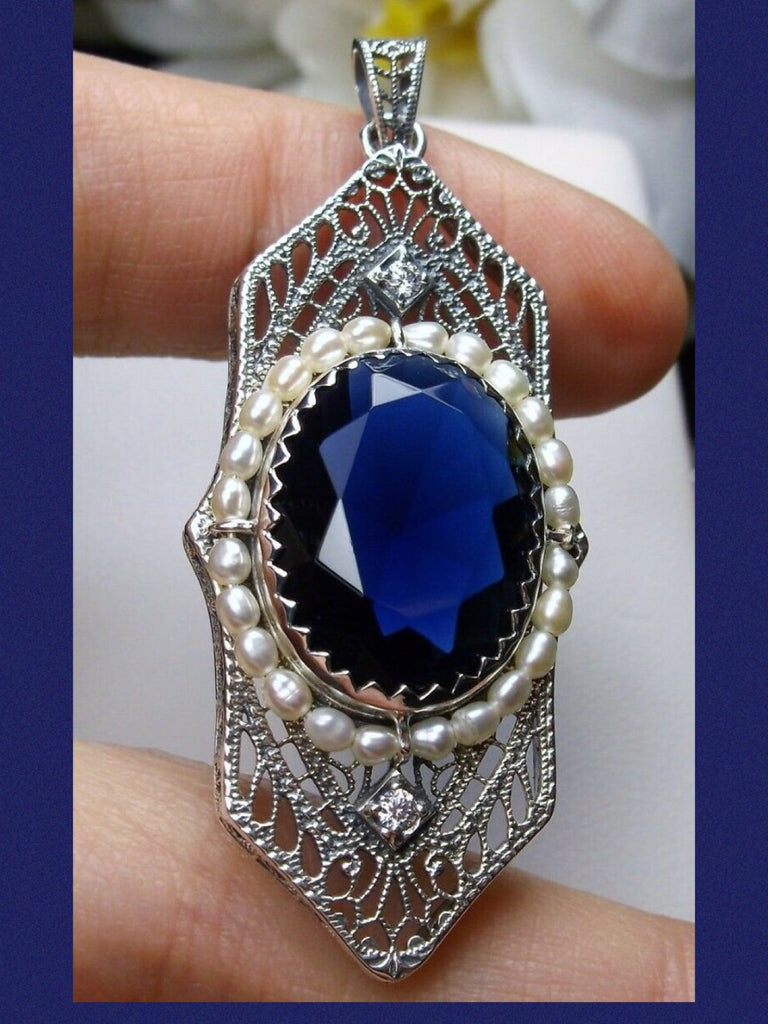 Blue Sapphire Pendant, Art Deco 1930s jewelry, seed pearl accents surround an oval gemstone with a sterling silver filigree background.  two White CZs adorn above and below the large brilliant focal gemstone, Silver Embrace Jewelry necklace