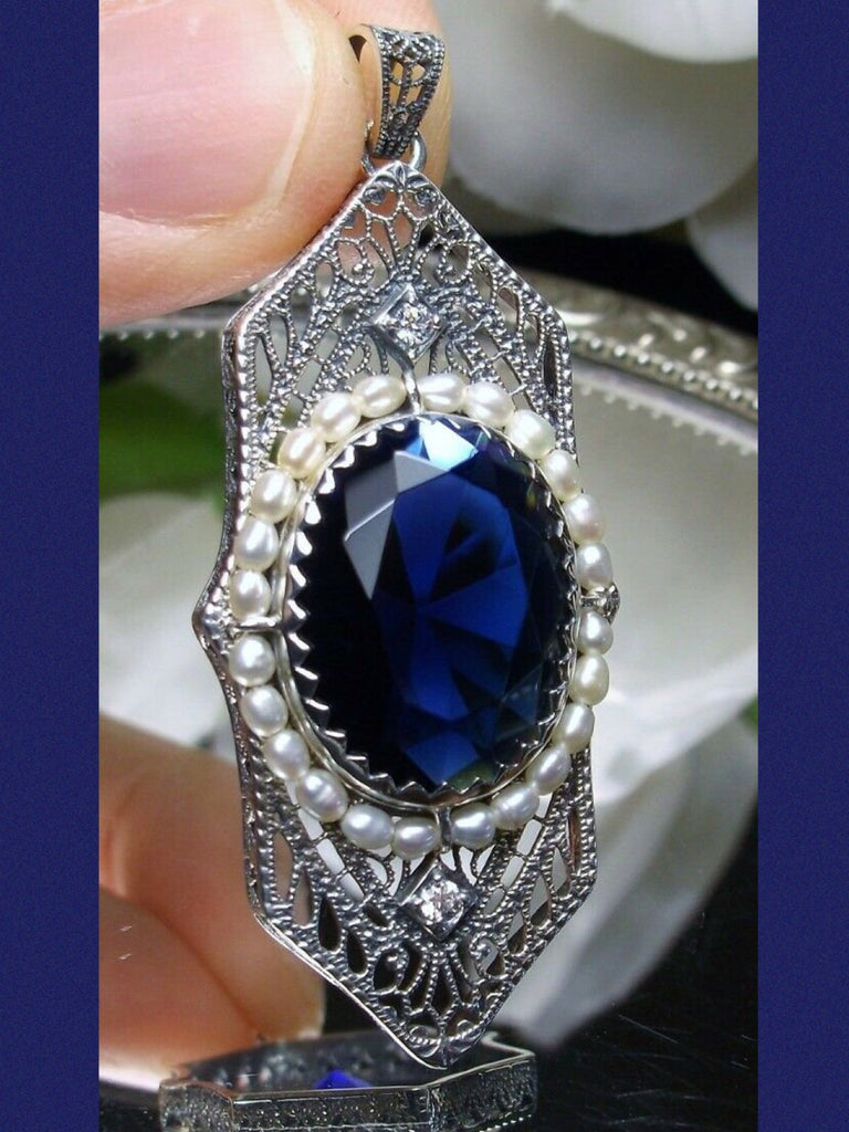 Blue Sapphire Pendant, Art Deco 1930s jewelry, seed pearl accents surround an oval gemstone with a sterling silver filigree background. two White CZs adorn above and below the large brilliant focal gemstone, Silver Embrace Jewelry necklace
