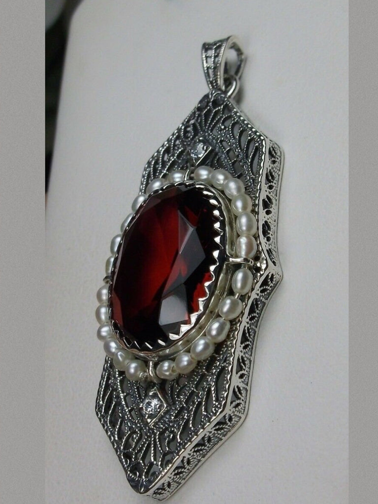 Red Ruby Pendant, Art Deco 1930s jewelry, seed pearl accents surround an oval gemstone with a sterling silver filigree background. two White CZs adorn above and below the large brilliant focal gemstone, Silver Embrace Jewelry necklace