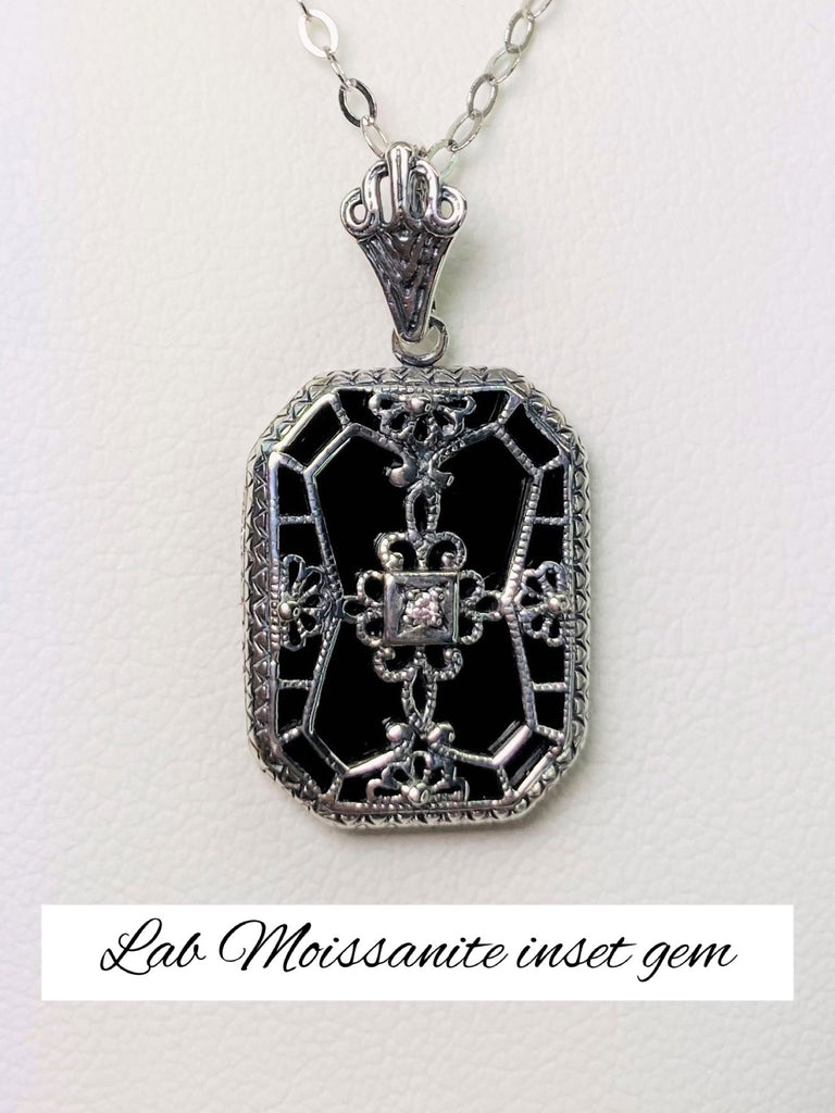 Black Glass pendant with a Moissanite gem inset in the center, sterling silver filigree edging and across the glass face in window pane style
