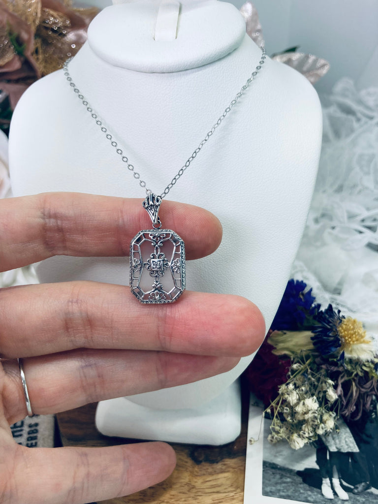 White Camphor Frosted Glass pendant with a CZ gem inset in the center, sterling silver filigree edging and across the glass face in window pane style