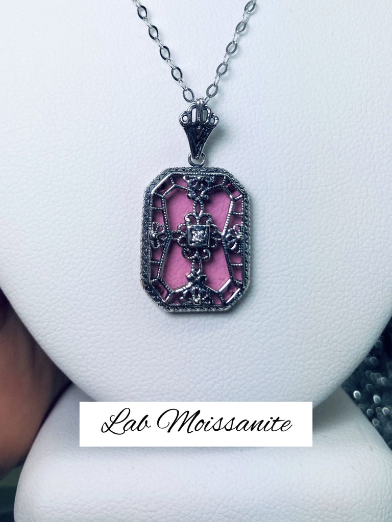 Pink Camphor Glass pendant with a Moissanite gem inset in the center, sterling silver filigree edging and across the glass face in window pane style
