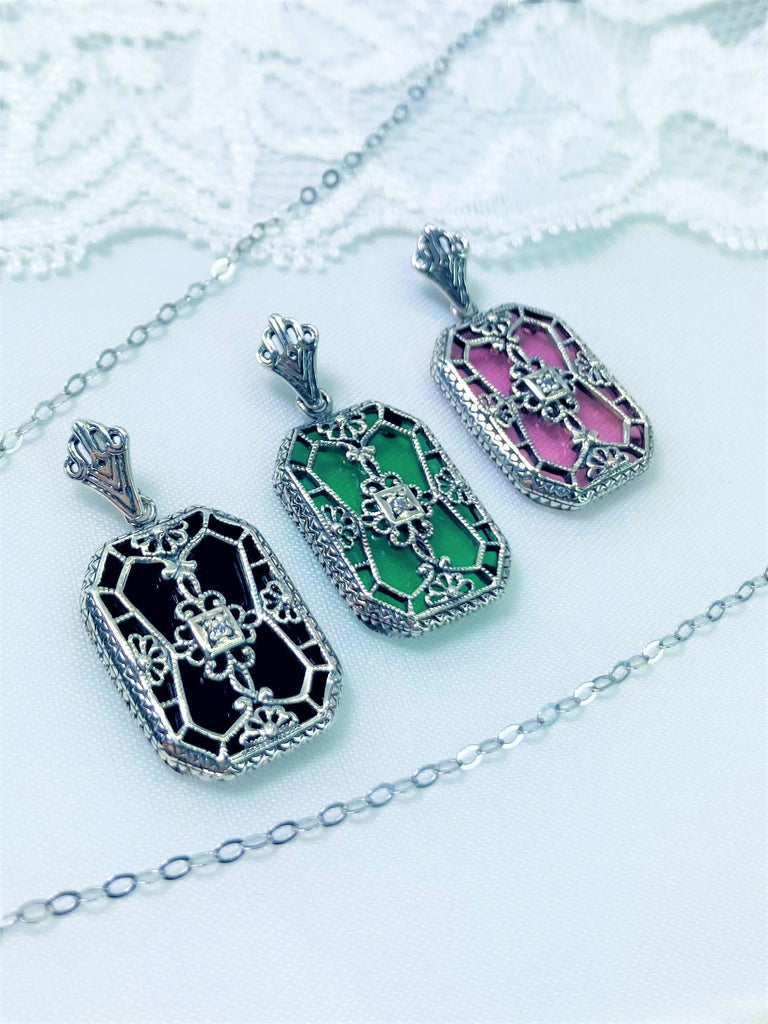 Glass pendant with a CZ gem inset in the center, sterling silver filigree edging and across the glass face in window pane style