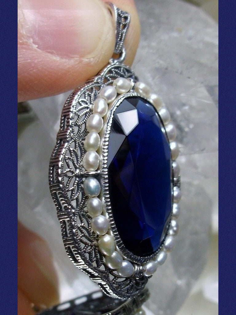 sapphire blue pendant with large deep blue oval gemstone surrounded by seed pearls and antique floral filigree, Silver Embrace Jewelry