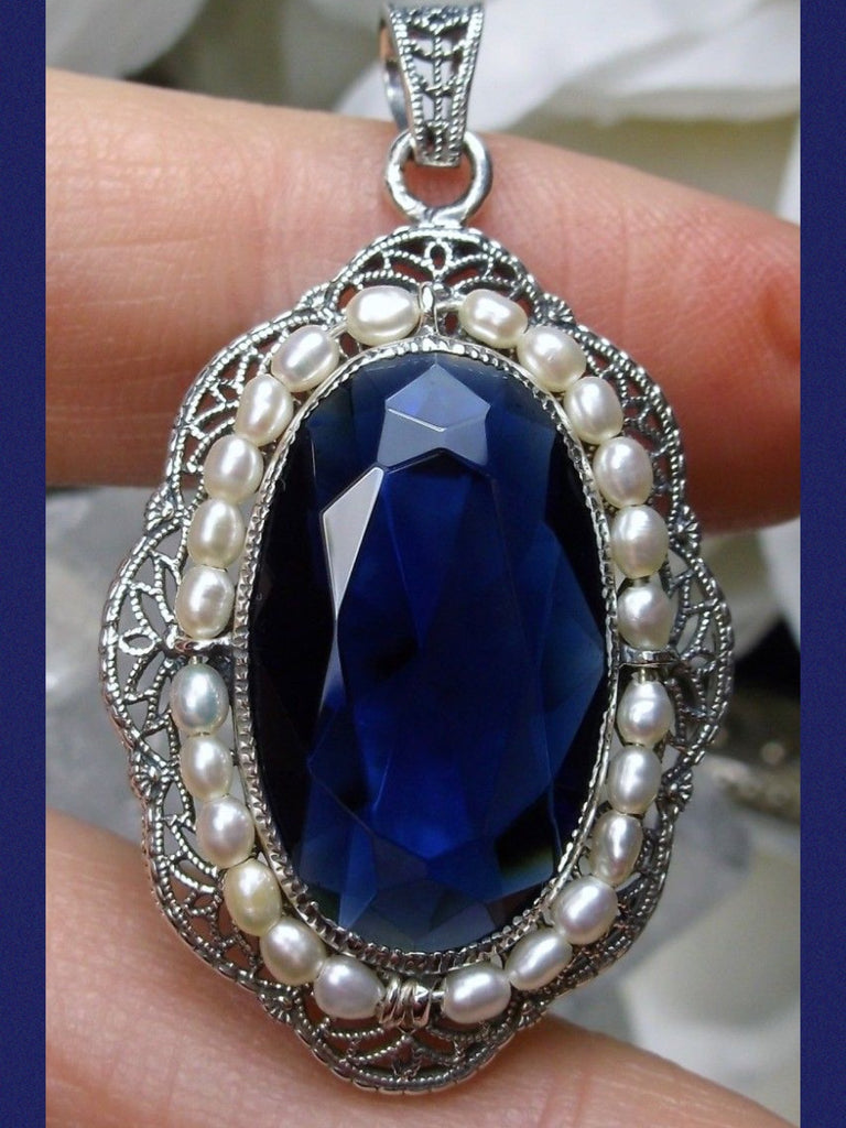 sapphire blue pendant with large deep blue oval gemstone surrounded by seed pearls and antique floral filigree, Silver Embrace Jewelry