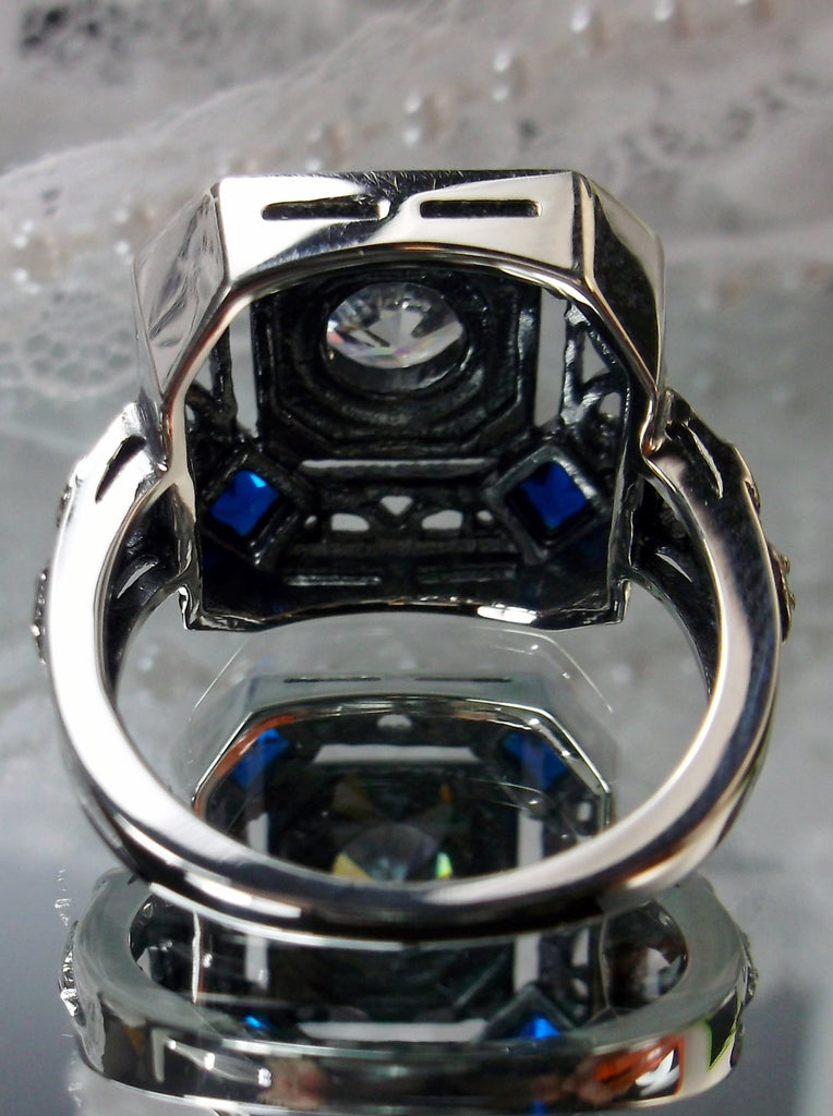 art deco style ring with a white CZ center stone and 4 deep blue gems in each corner of the octagonal filigree