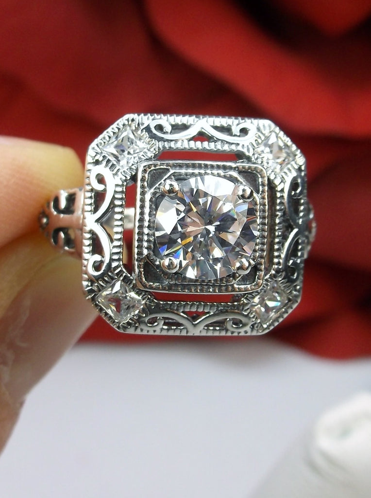 art deco style ring with a white CZ, faux diamond center stone and 4 faux diamond gems in each corner of the octagonal filigree
