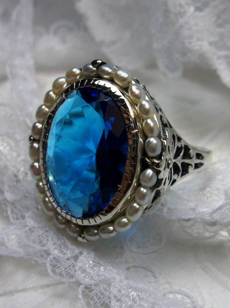 Swiss Blue Topaz Ring, Seed Pearls surround and accent the simulated oval stone with sterling silver Victorian filigree