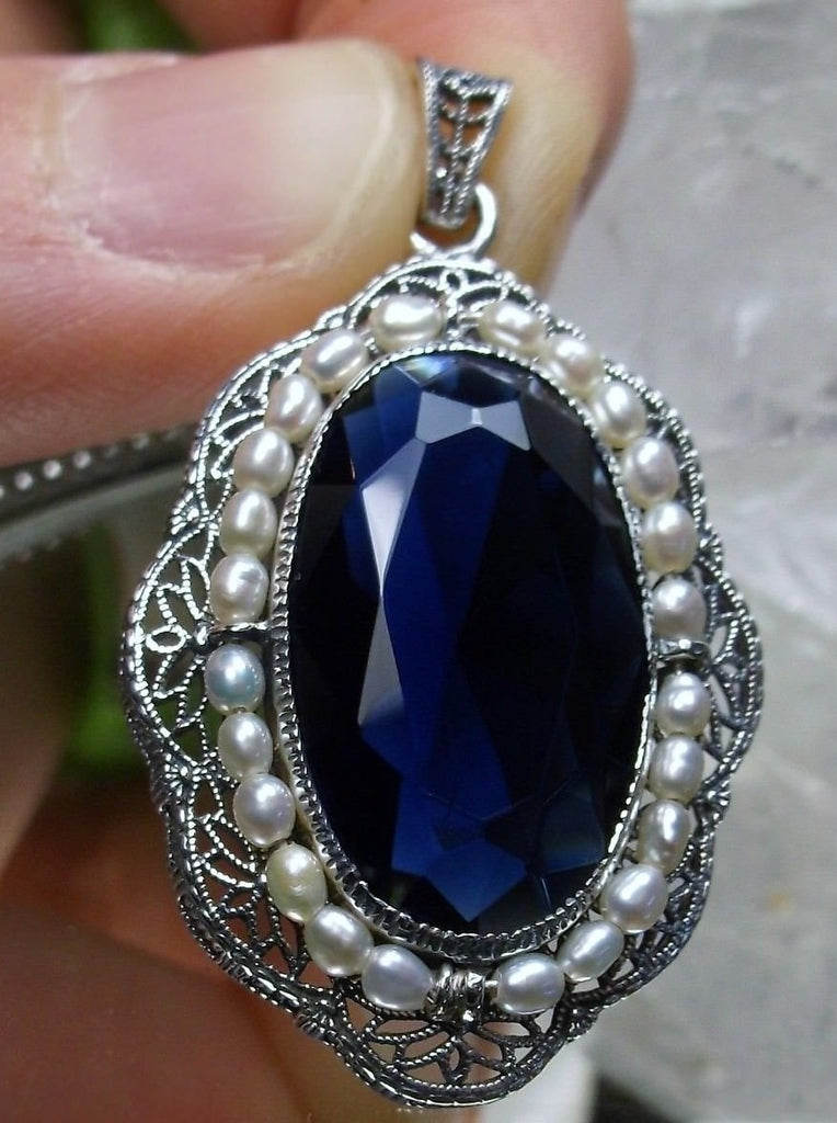 sapphire blue pendant with large deep blue oval gemstone surrounded by seed pearls and antique floral filigree, Silver Embrace Jewerly