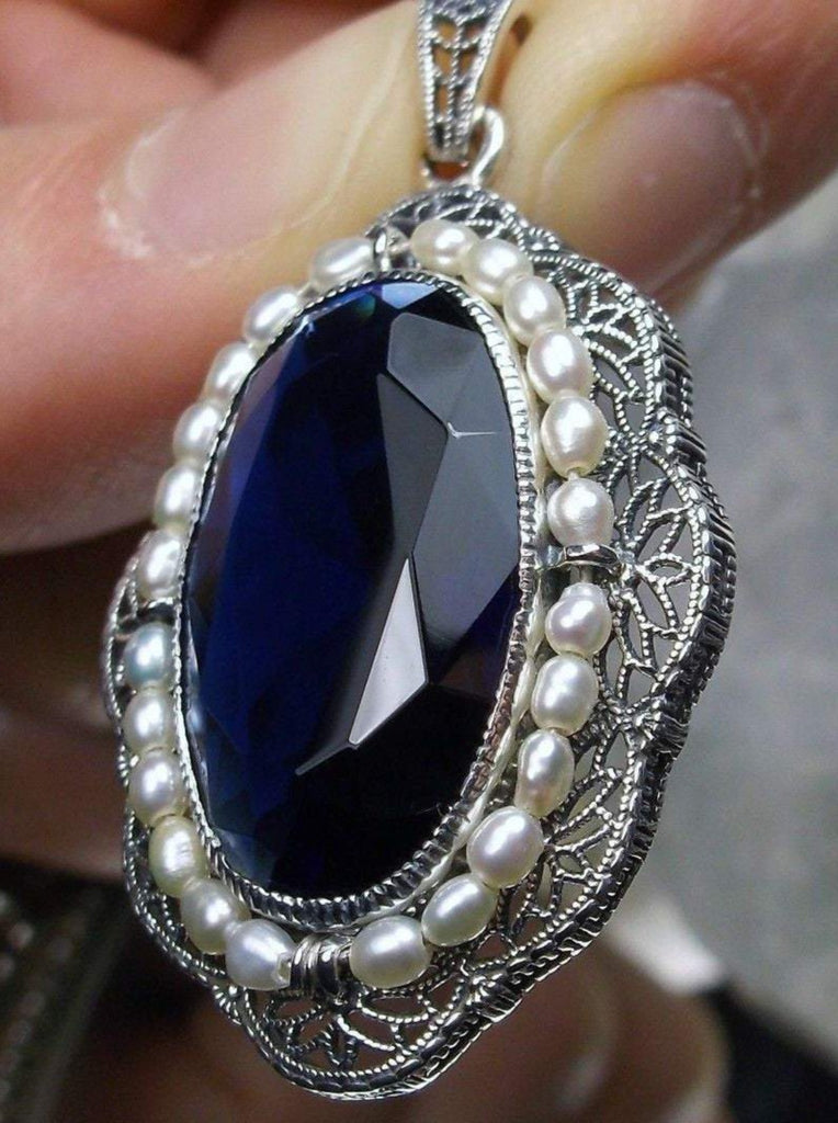 sapphire blue pendant with large deep blue oval gemstone surrounded by seed pearls and antique floral filigree, Silver Embrace Jewerly
