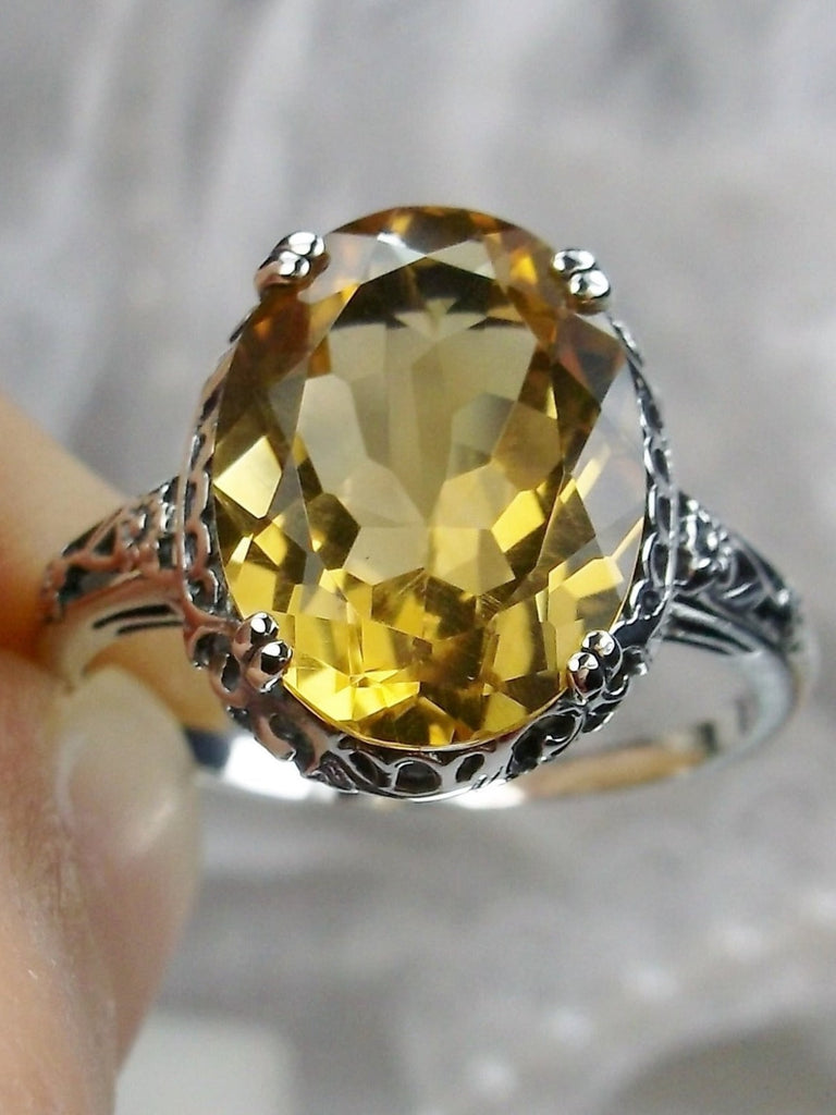 Natural Citrine Ring, Oval yellow citrine gemstone, sterling silver floral filigree, Edward Design #D70, top offset view held in fingers