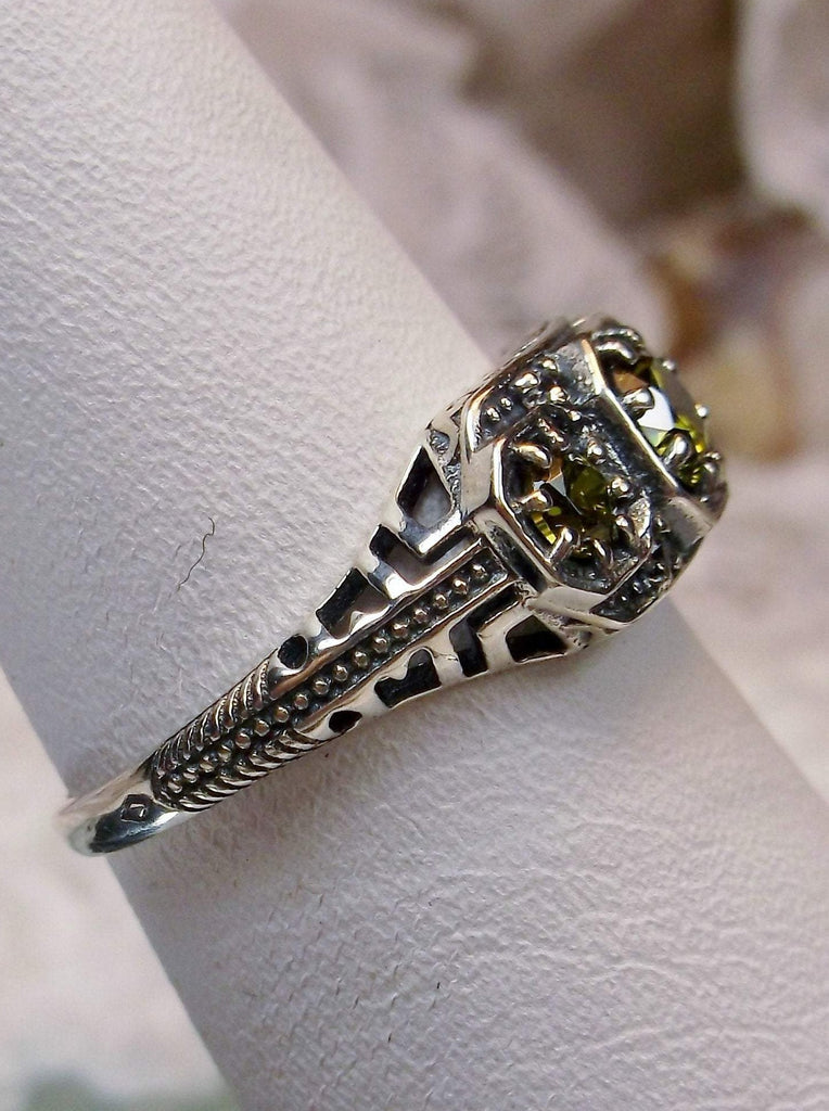 Art deco style ring with three green peridot gems set in sterling silver filigree