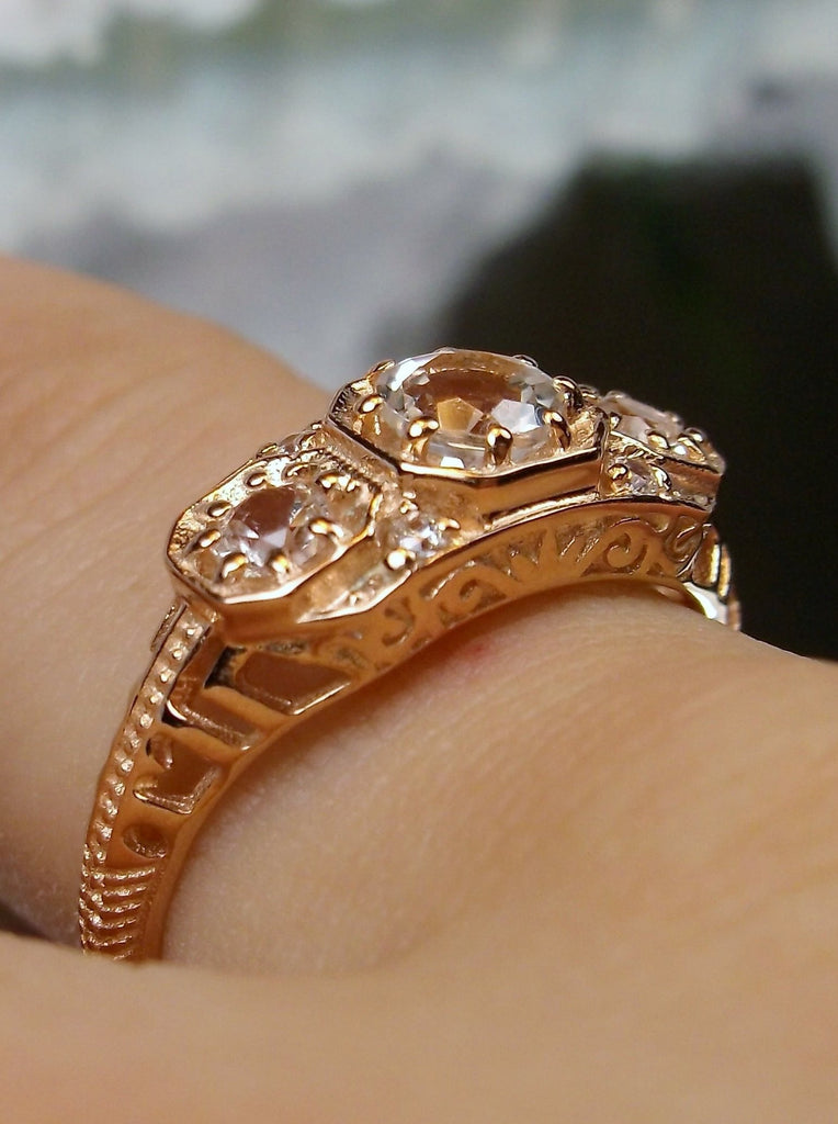Art deco style ring with three natural white topaz gems set in rose gold filigree