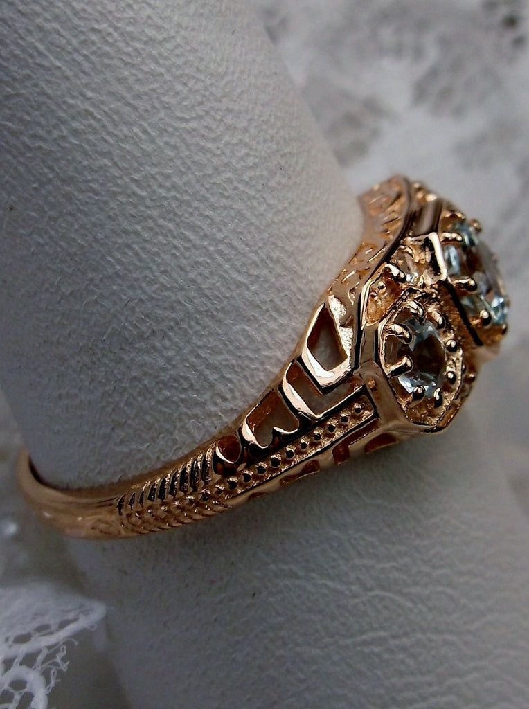 Art deco style ring with three sky blue topaz gems set in rose gold filigree
