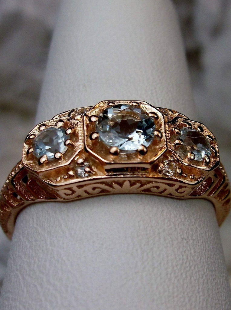 Art deco style ring with three sky blue topaz gems set in rose gold filigree