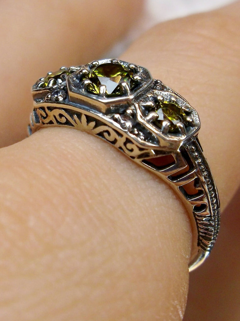 Art deco style ring with three green peridot gems set in sterling silver filigree