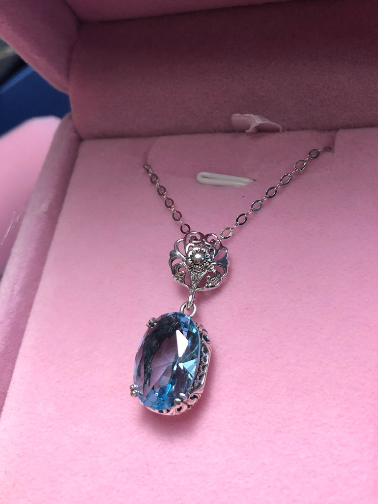Aquamarine pendant necklace, with an oval sky blue stone set in floral sterling silver filigree, 4 prongs hold the gem in place, Silver Embrace Jewelry