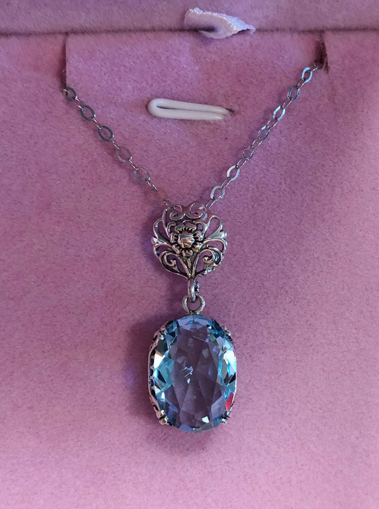 Aquamarine pendant necklace, with an oval sky blue stone set in floral sterling silver filigree, 4 prongs hold the gem in place, Silver Embrace Jewelry