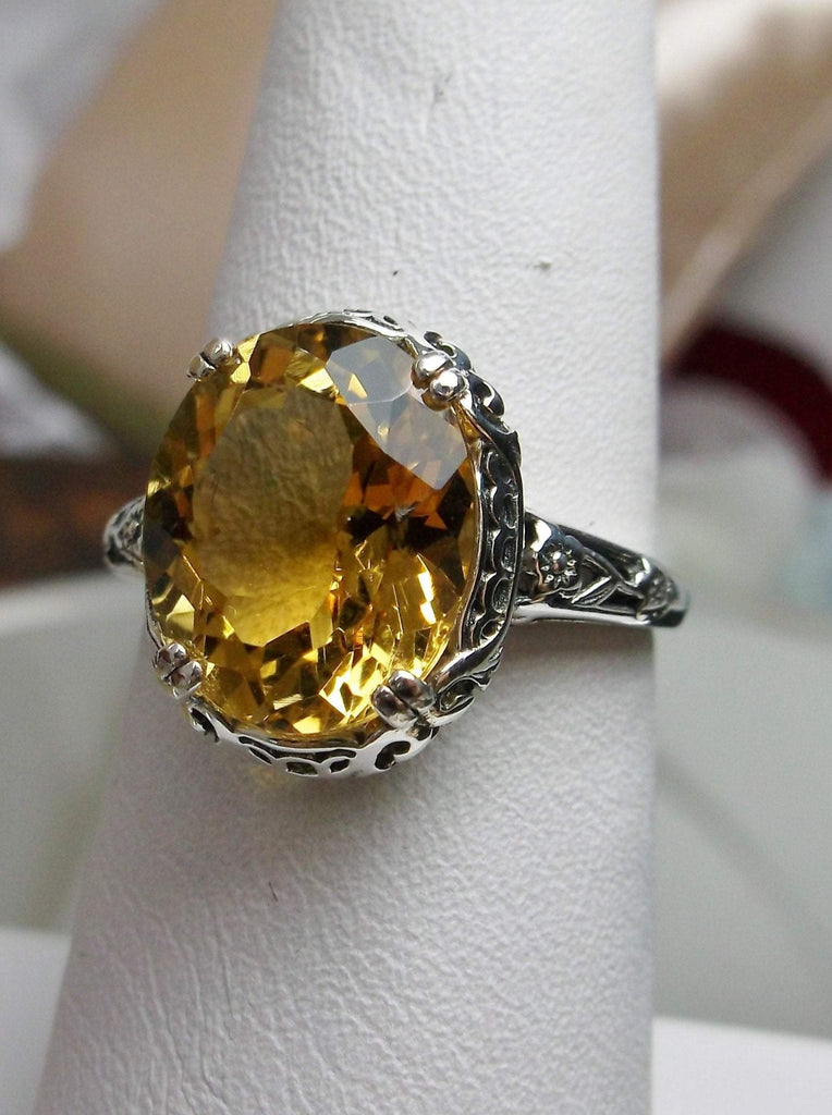 Natural Citrine Ring, Oval yellow citrine gemstone, sterling silver floral filigree, Edward Design #D70z, front side view on a ring holder
