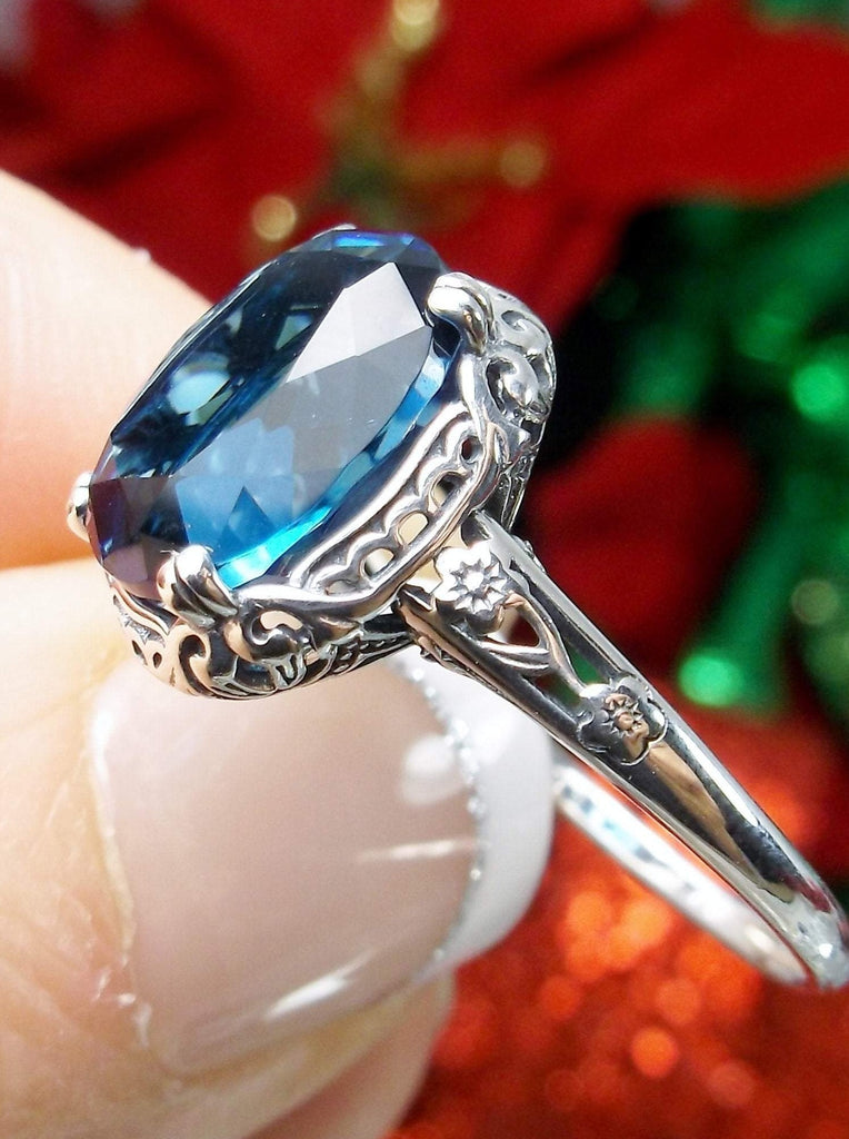 London Blue Topaz Ring, oval simulated topaz, sterling silver floral filigree, Edward design #70z, side view held in fingers