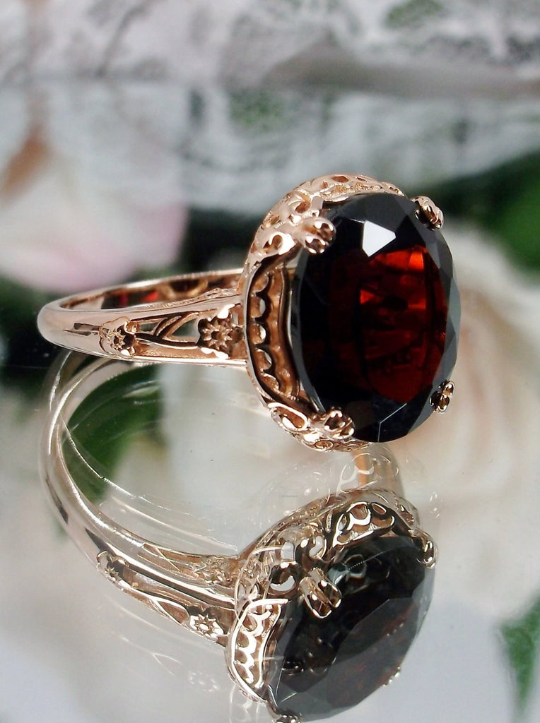 Natural Garnet Ring, Rose Gold over Sterling Silver, floral filigree setting and band, oval garnet stone, Edward design#70z, offset front and side view on a mirror
